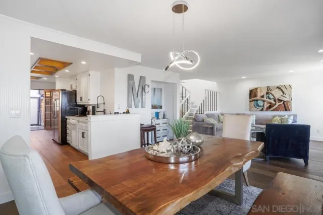 a kitchen with stainless steel appliances kitchen island granite countertop a dining table and chairs with wooden floor