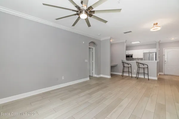 a view of a livingroom with a ceiling fan wooden floor and a window