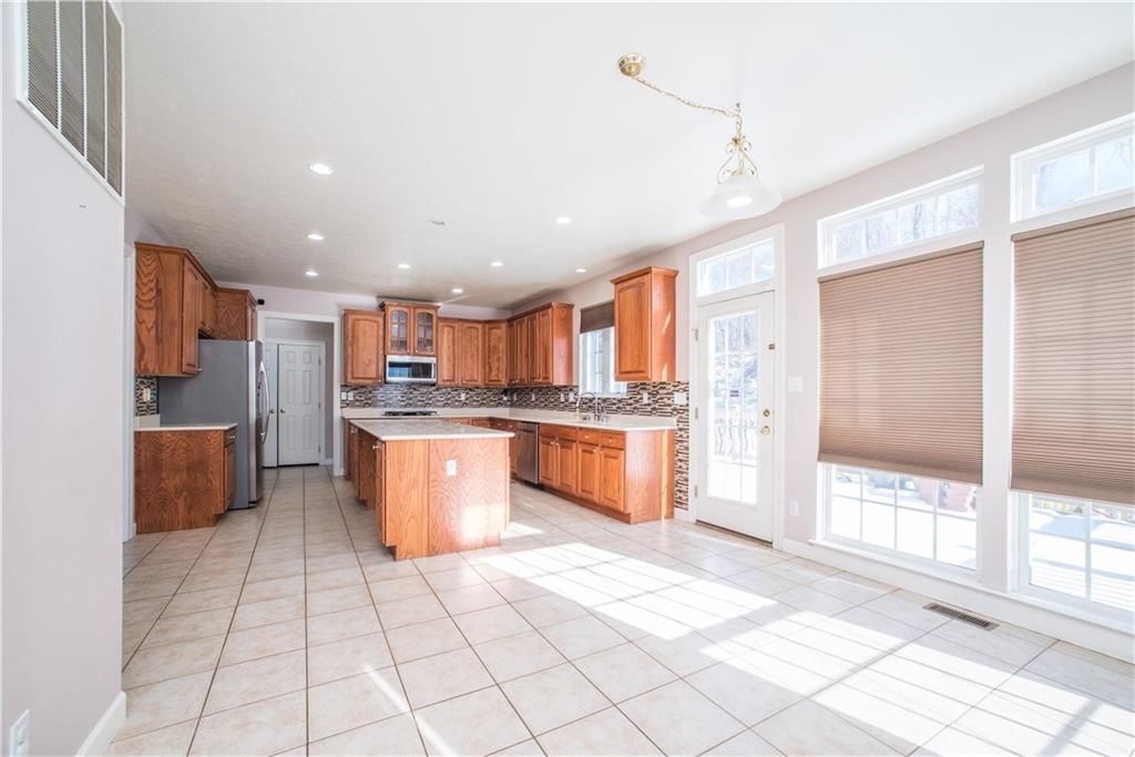 8404 David Drive Bridgeville, PA 15017 - Photo 5 of 25 a large kitchen with stainless steel appliances kitchen island granite countertop a refrigerator and a stove top oven