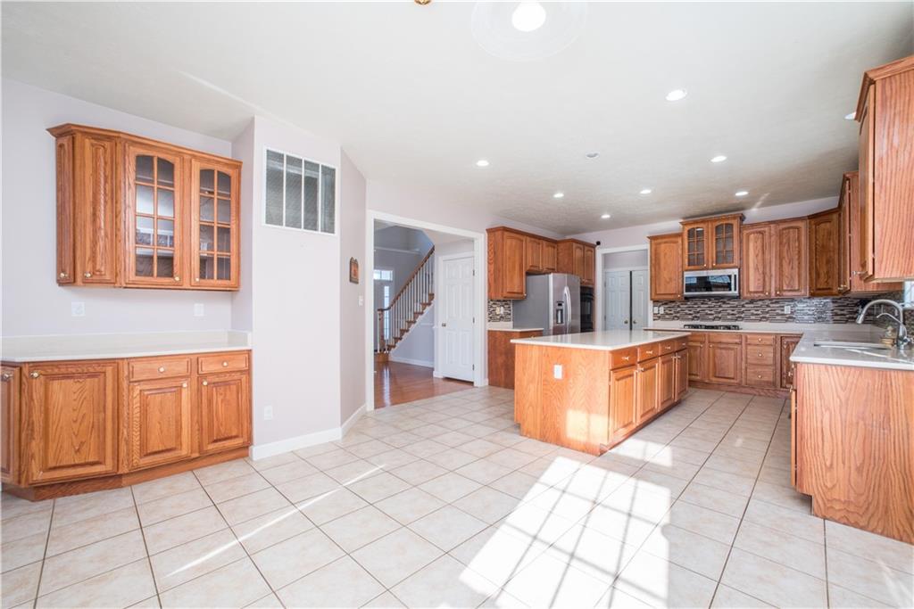 8404 David Drive Bridgeville, PA 15017 - Photo 6 of 25 a large kitchen with stainless steel appliances kitchen island granite countertop a large counter top and a stove top oven