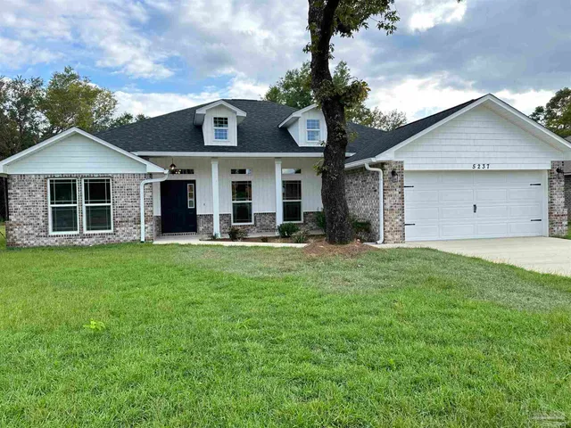 a front view of a house with a garden and yard