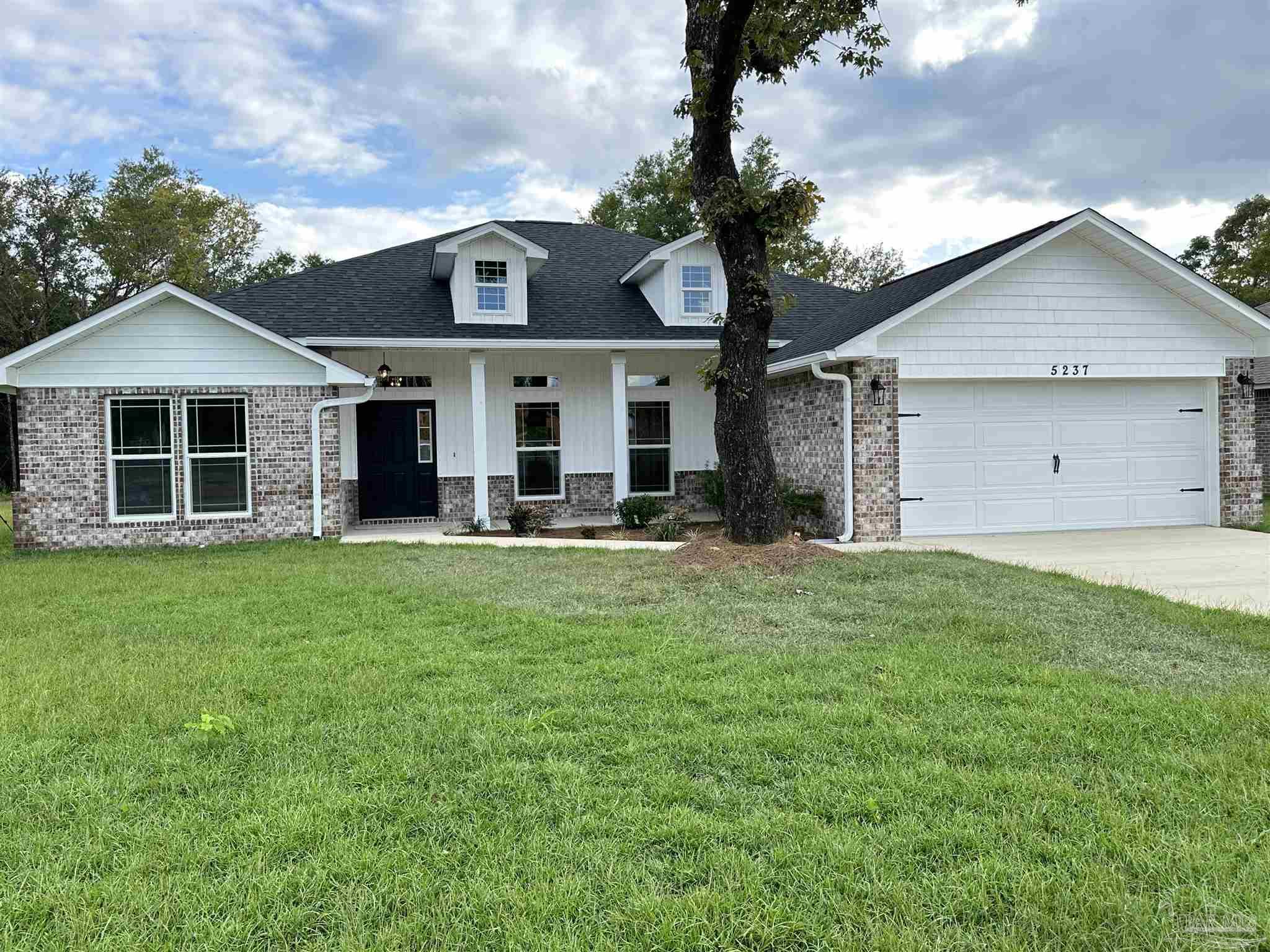 a front view of a house with a garden and yard