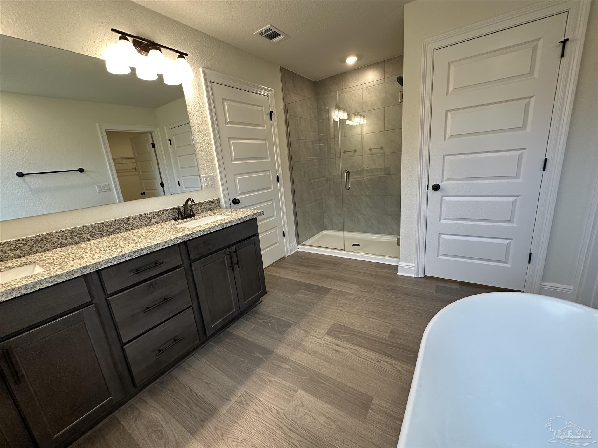 5214 Barnett Road Milton, FL 32583 - Photo 16 of 22 a bathroom with a double vanity sink a large mirror and a shower