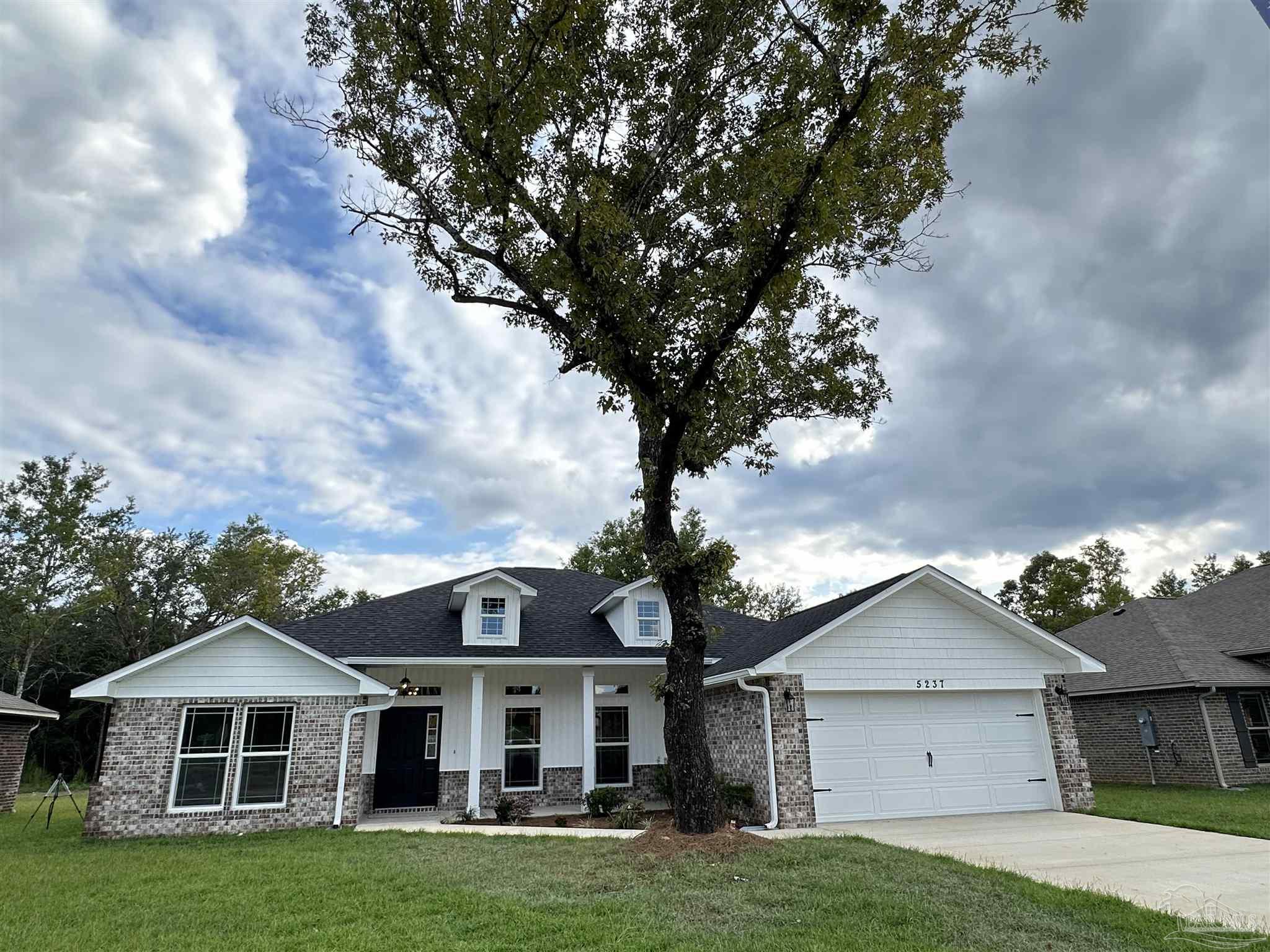 5214 Barnett Road Milton, FL 32583 - Photo 2 of 22 a front view of a house with a garden and trees