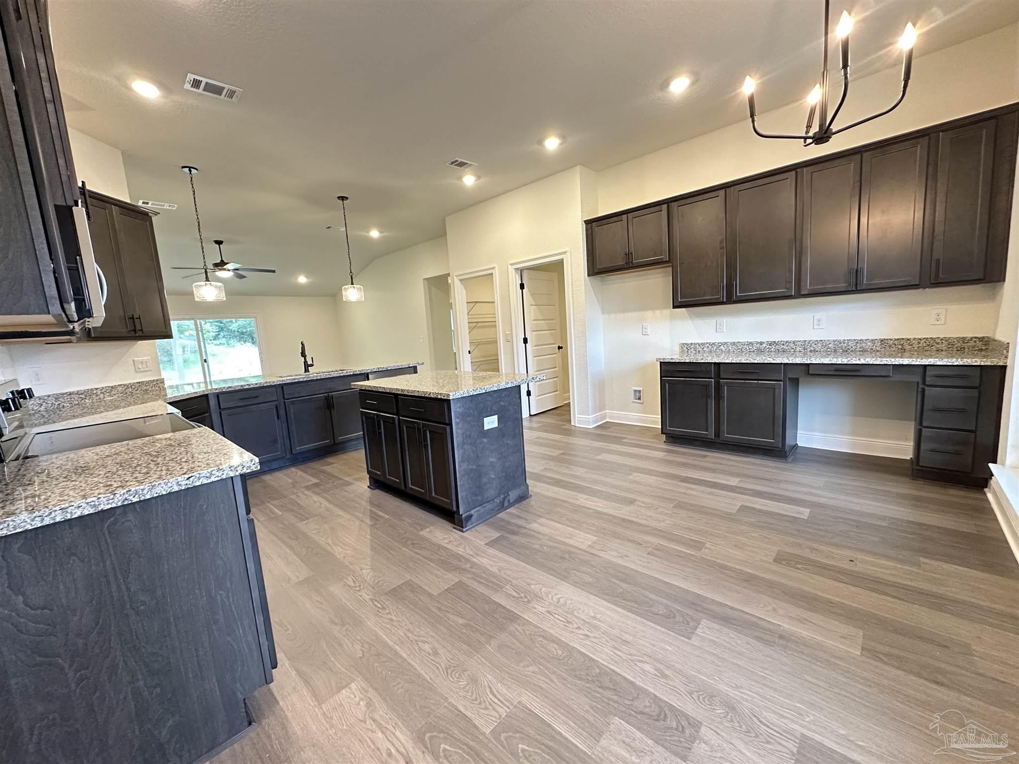 5214 Barnett Road Milton, FL 32583 - Photo 4 of 22 a large kitchen with stainless steel appliances kitchen island a large counter top a sink and a stove