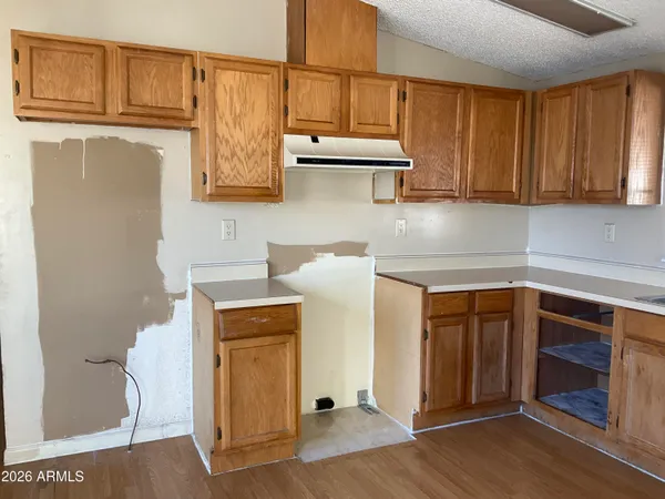 a kitchen with stainless steel appliances granite countertop a refrigerator a stove and white cabinets with wooden floor