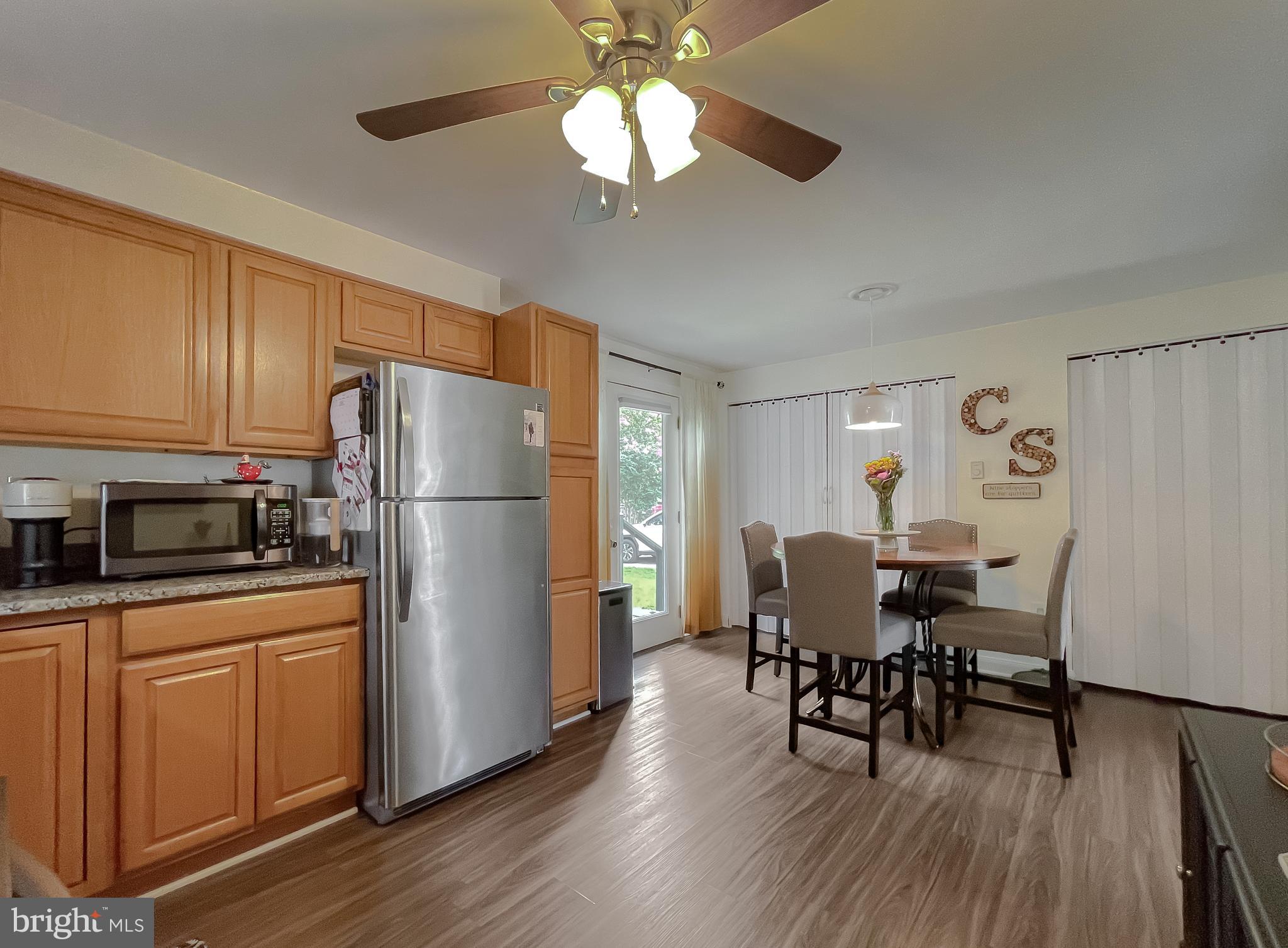 916 Crystal Rock Road Lusby, MD 20657 - Photo 12 of 44 a kitchen with stainless steel appliances a dining table chairs refrigerator and sink