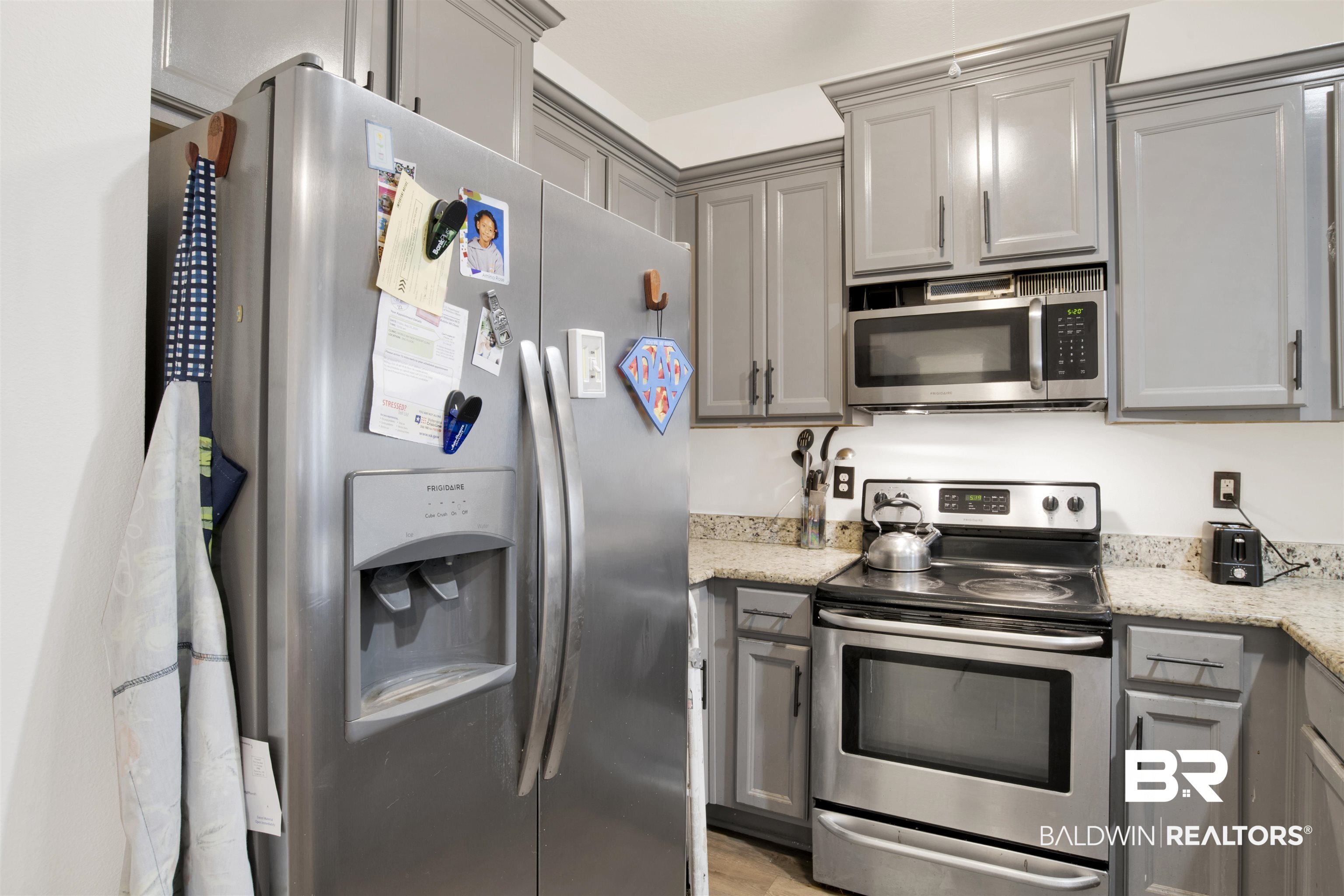 25806 Pollard Road, Unit 80 Daphne, AL 36526 - Photo 14 of 30 Kitchen with gray cabinets, stainless steel appliances, and light stone counters