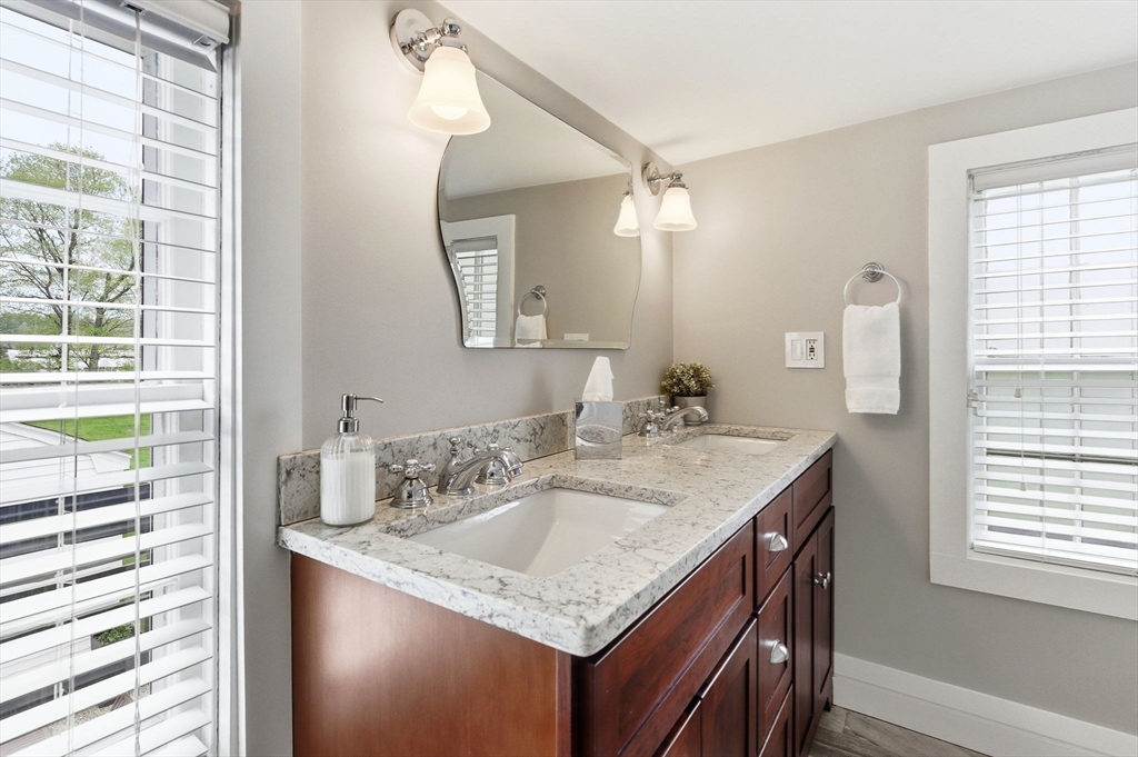 5 Great Road Bedford, MA 01730 - Photo 23 of 42 a bathroom with a granite countertop sink a mirror and a window