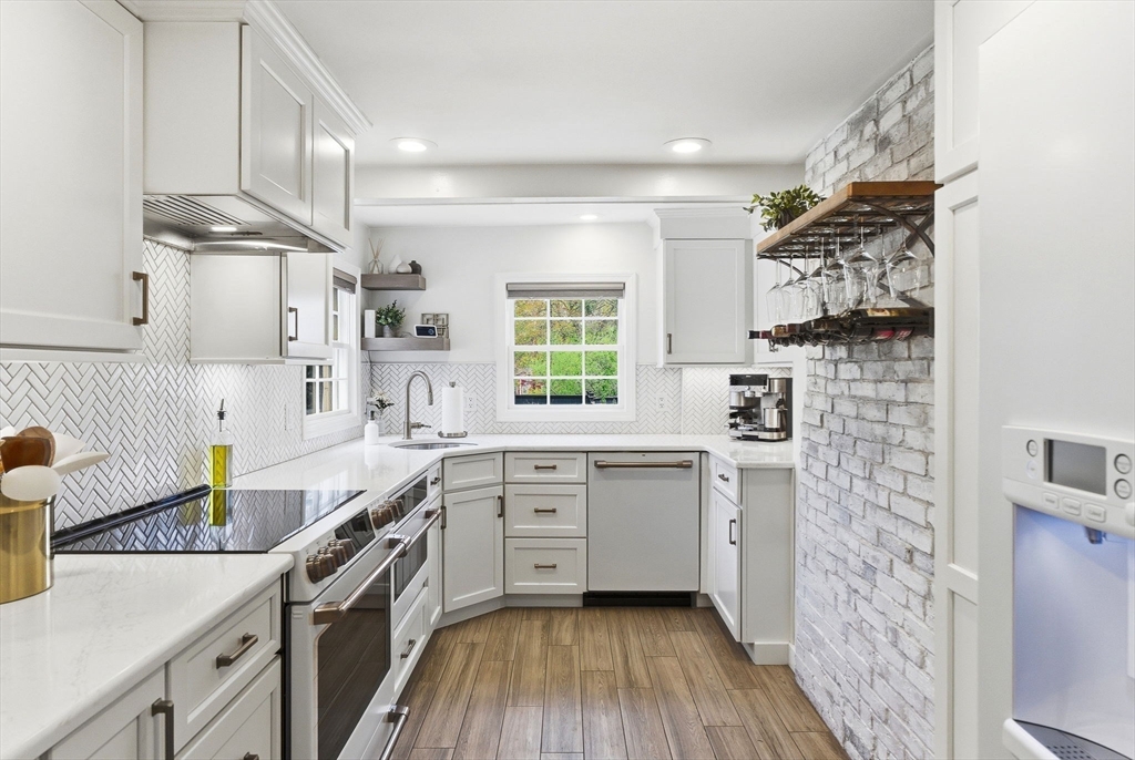 5 Great Road Bedford, MA 01730 - Photo 8 of 42 a kitchen with stainless steel appliances a sink stove and wooden floor