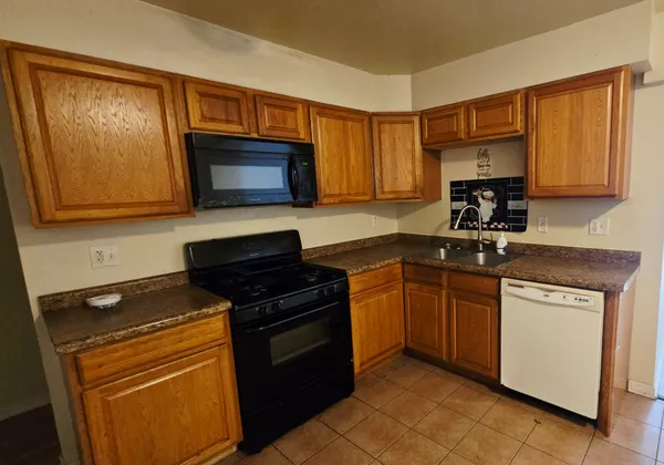 a kitchen with a sink stove top oven and cabinets