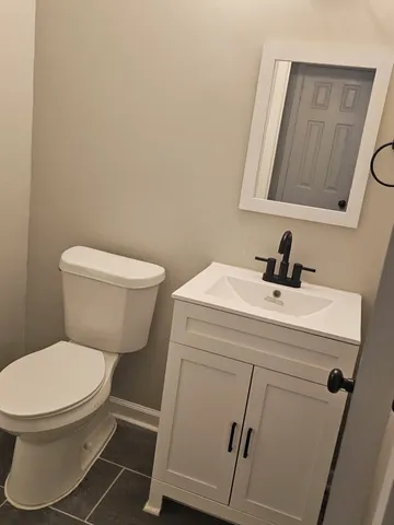 a bathroom with a toilet sink and mirror