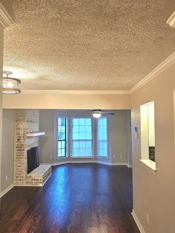 a view of an empty room with window and fire place