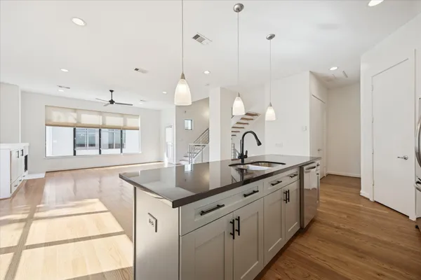 a kitchen with sink stove and wooden floor