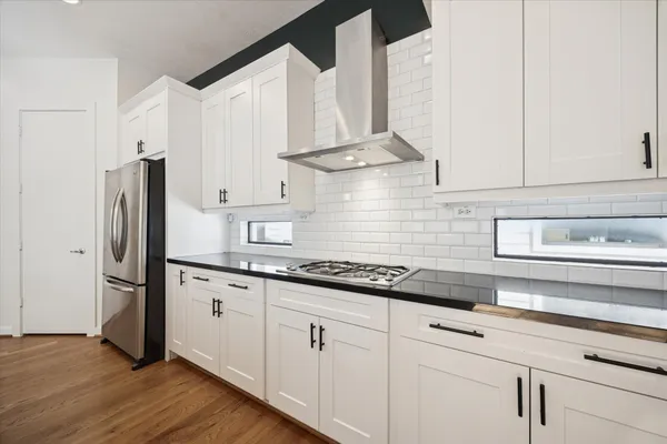 a kitchen with stainless steel appliances white cabinets and a refrigerator