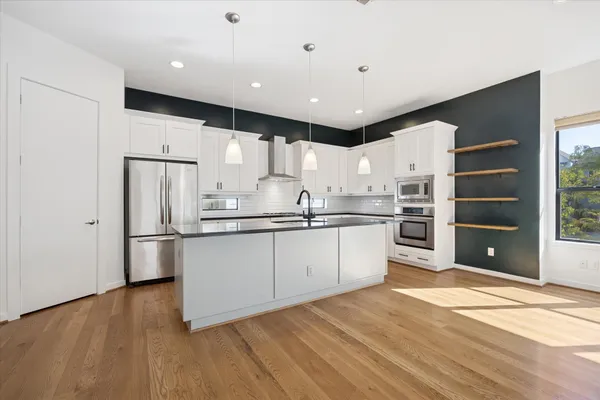 a kitchen with stainless steel appliances a refrigerator sink and cabinets