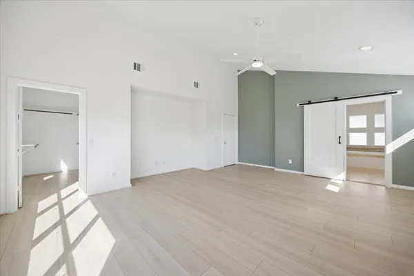 a view of empty room with wooden floor and a bathroom