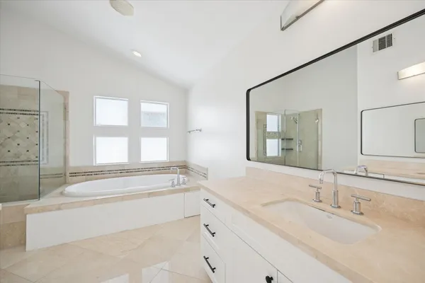 a spacious bathroom with sink shower and bathtub