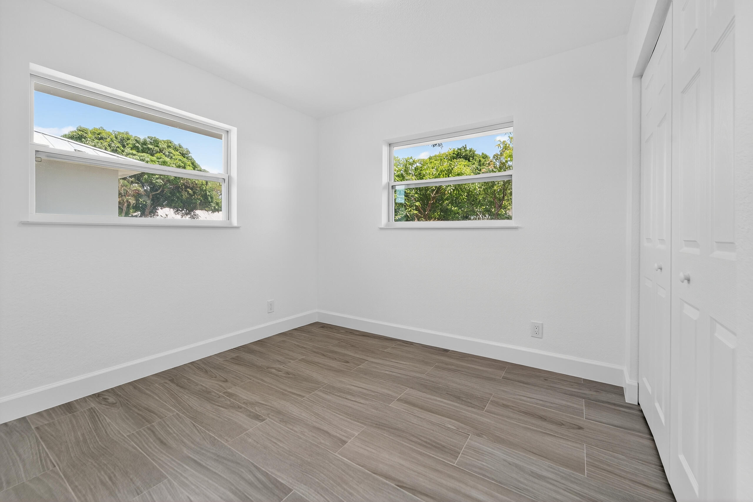 6830 2nd Street Jupiter, FL 33458 - Photo 15 of 34 a view of an empty room with wooden floor and a window