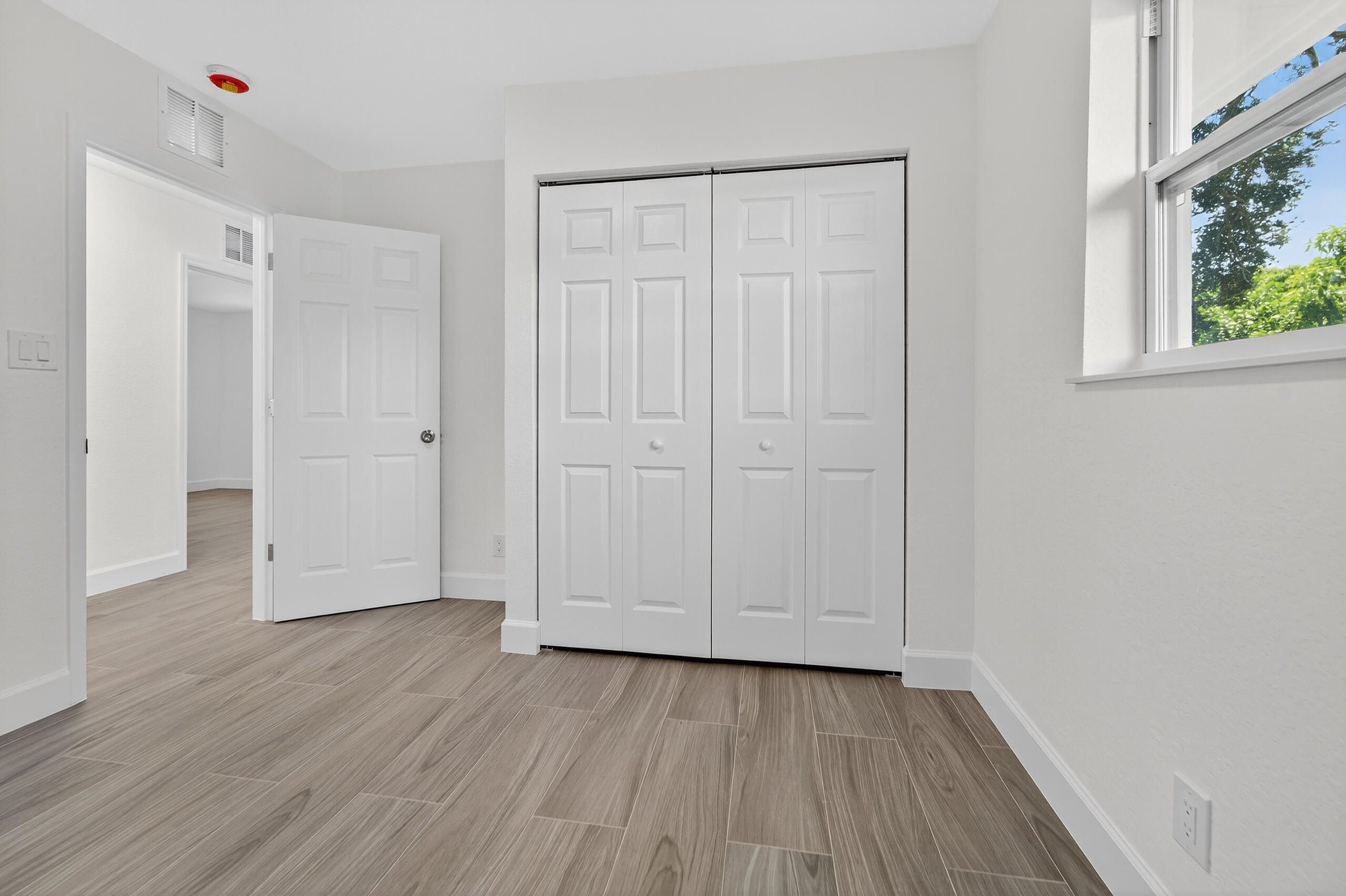 6830 2nd Street Jupiter, FL 33458 - Photo 19 of 34 a view of an empty room with wooden floor and a window