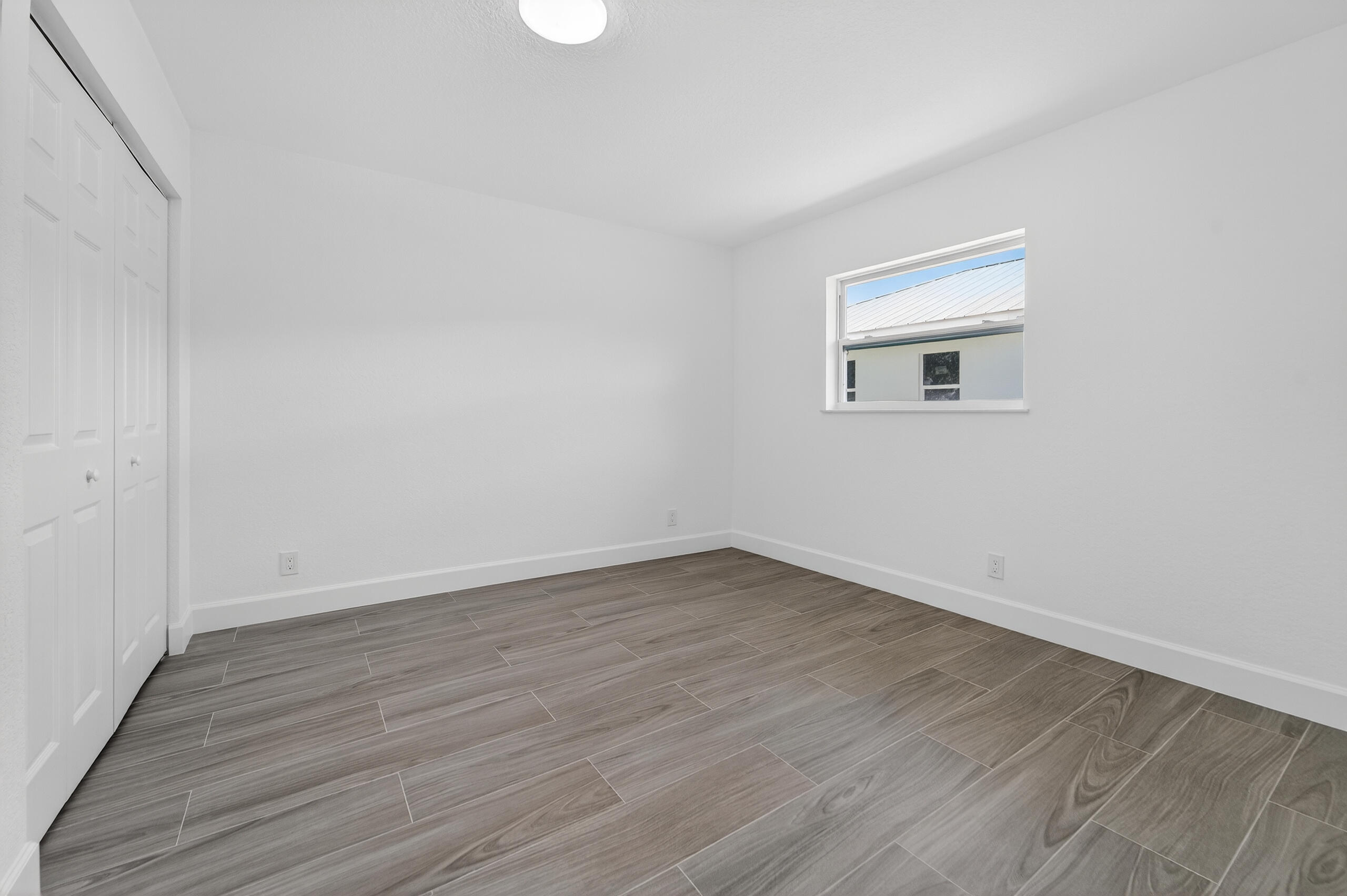 6830 2nd Street Jupiter, FL 33458 - Photo 20 of 34 a view of an empty room with wooden floor and a window
