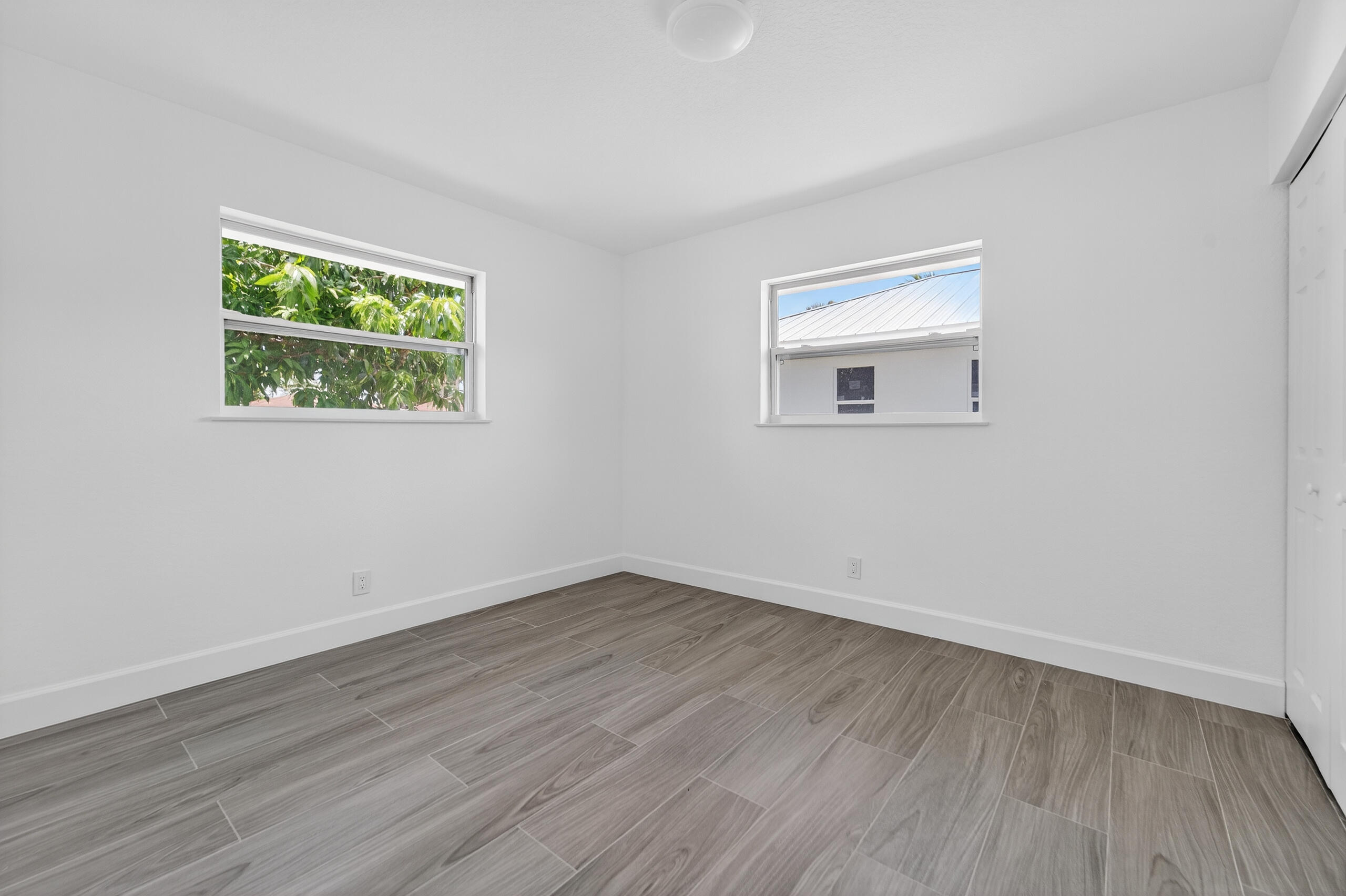 6830 2nd Street Jupiter, FL 33458 - Photo 22 of 34 a view of an empty room with wooden floor and a window