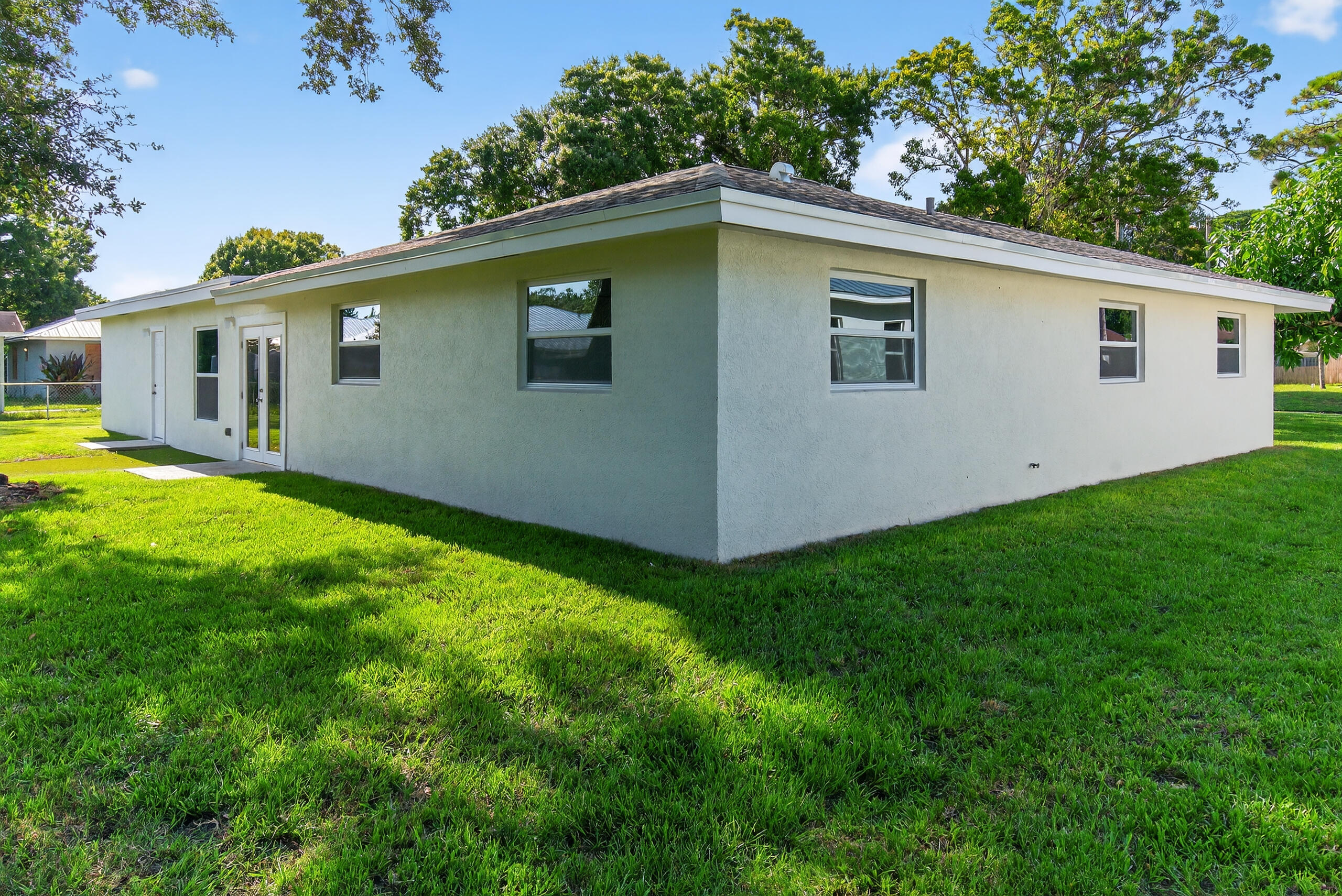 6830 2nd Street Jupiter, FL 33458 - Photo 32 of 34 a side view of backyard of house with green space