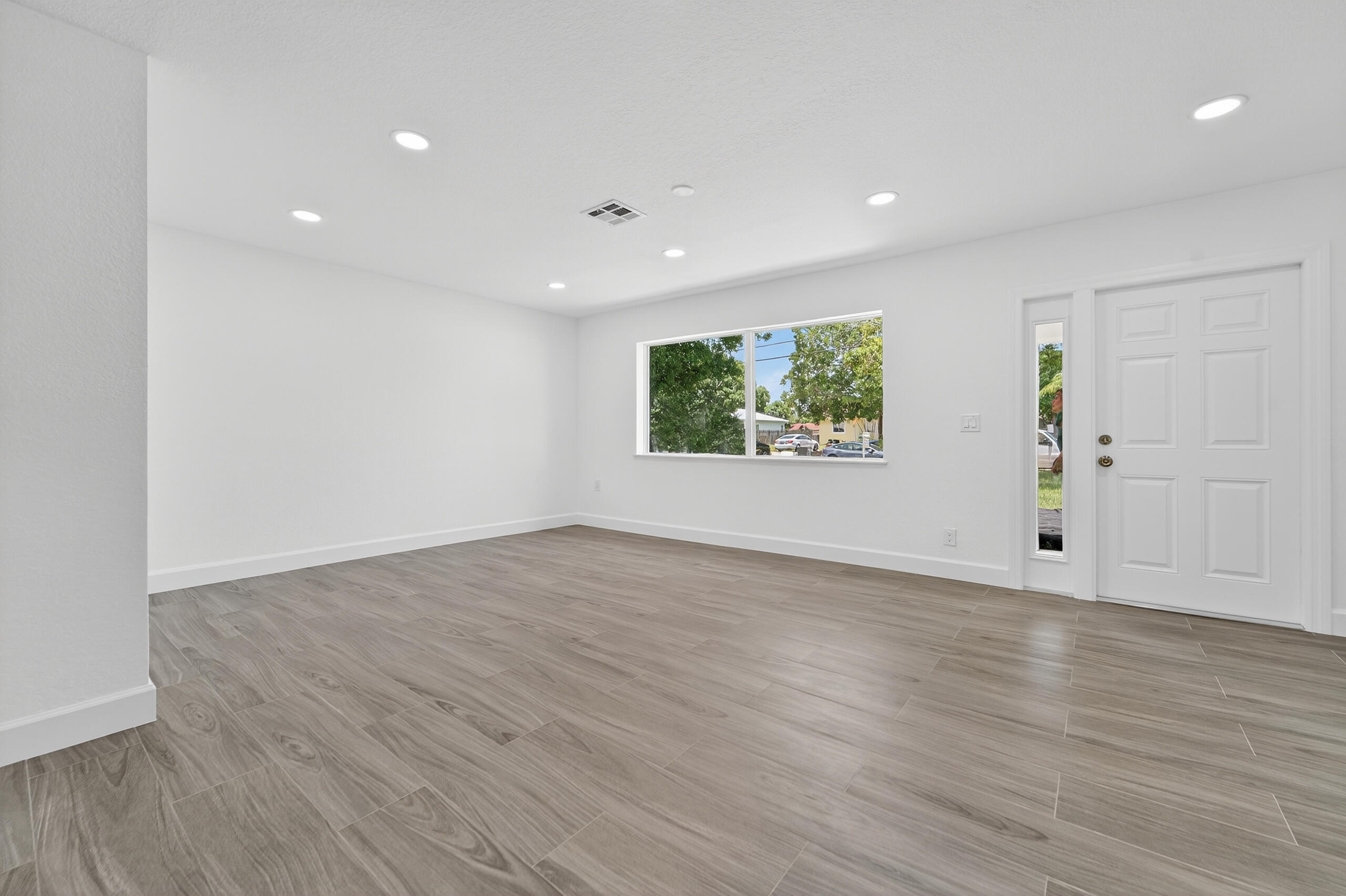 6830 2nd Street Jupiter, FL 33458 - Photo 6 of 34 an empty room with wooden floor and windows