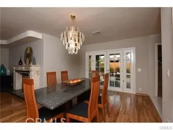 a dining room with furniture a chandelier and wooden floor