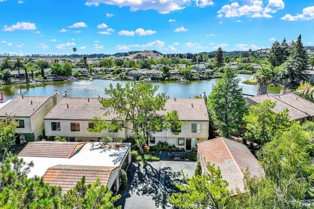 a front view of a house with a yard and potted plants
