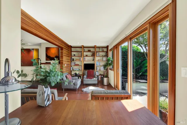 a view of an empty room with wooden floor and windows