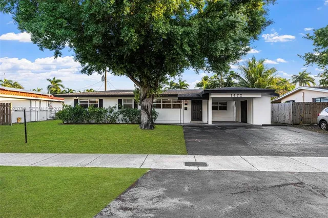 a front view of a house with a yard and trees