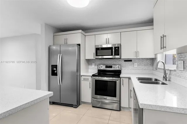 a kitchen with stainless steel appliances granite countertop a refrigerator stove and sink