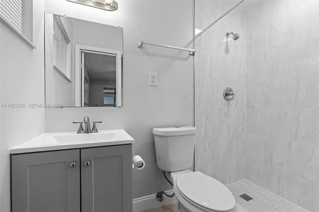 a bathroom with a toilet a sink a mirror and vanity