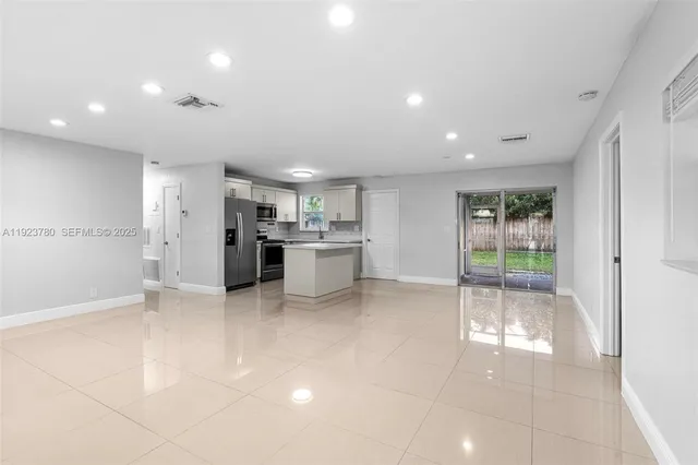 a view of a kitchen with refrigerator and white cabinets