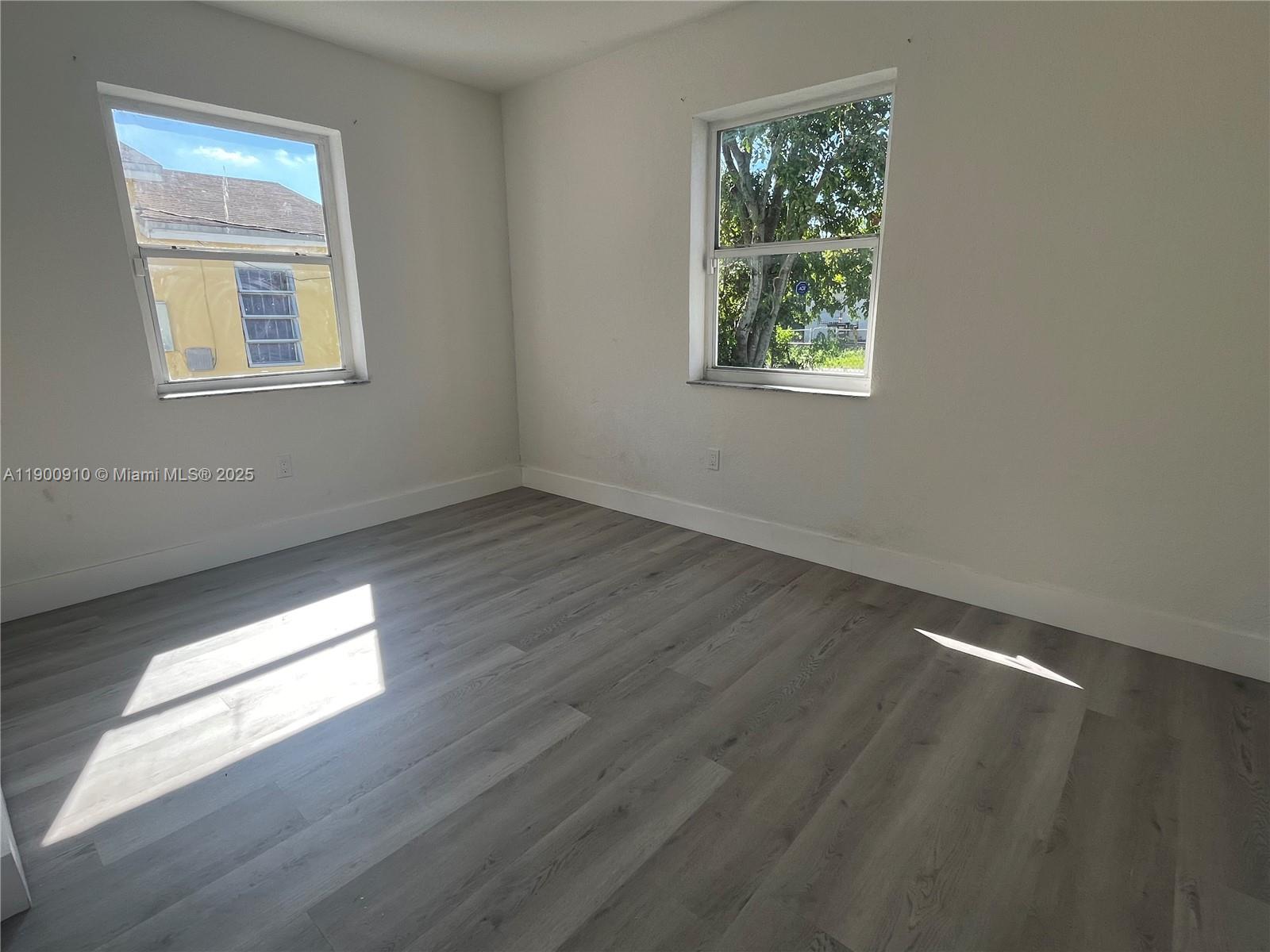 1923 Northwest 66th Street Miami, FL 33147 - Photo 14 of 27 a view of an empty room with wooden floor and a window