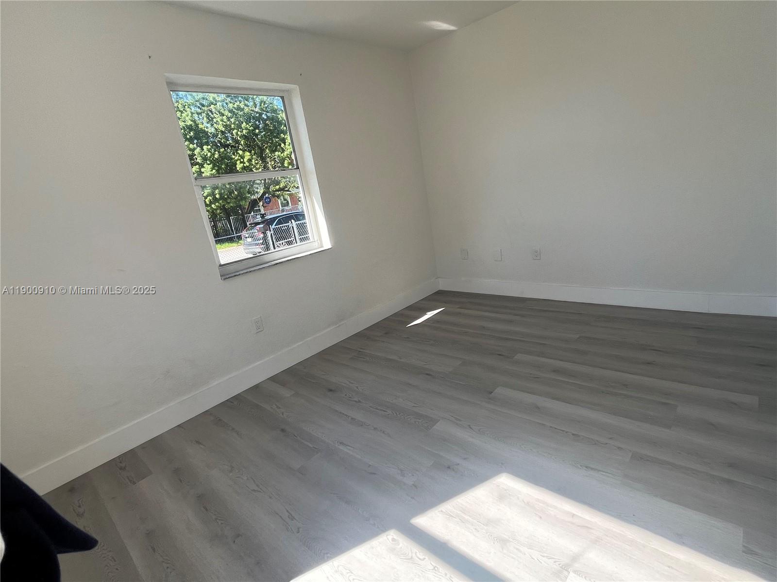 1923 Northwest 66th Street Miami, FL 33147 - Photo 15 of 27 an empty room with wooden floor and windows