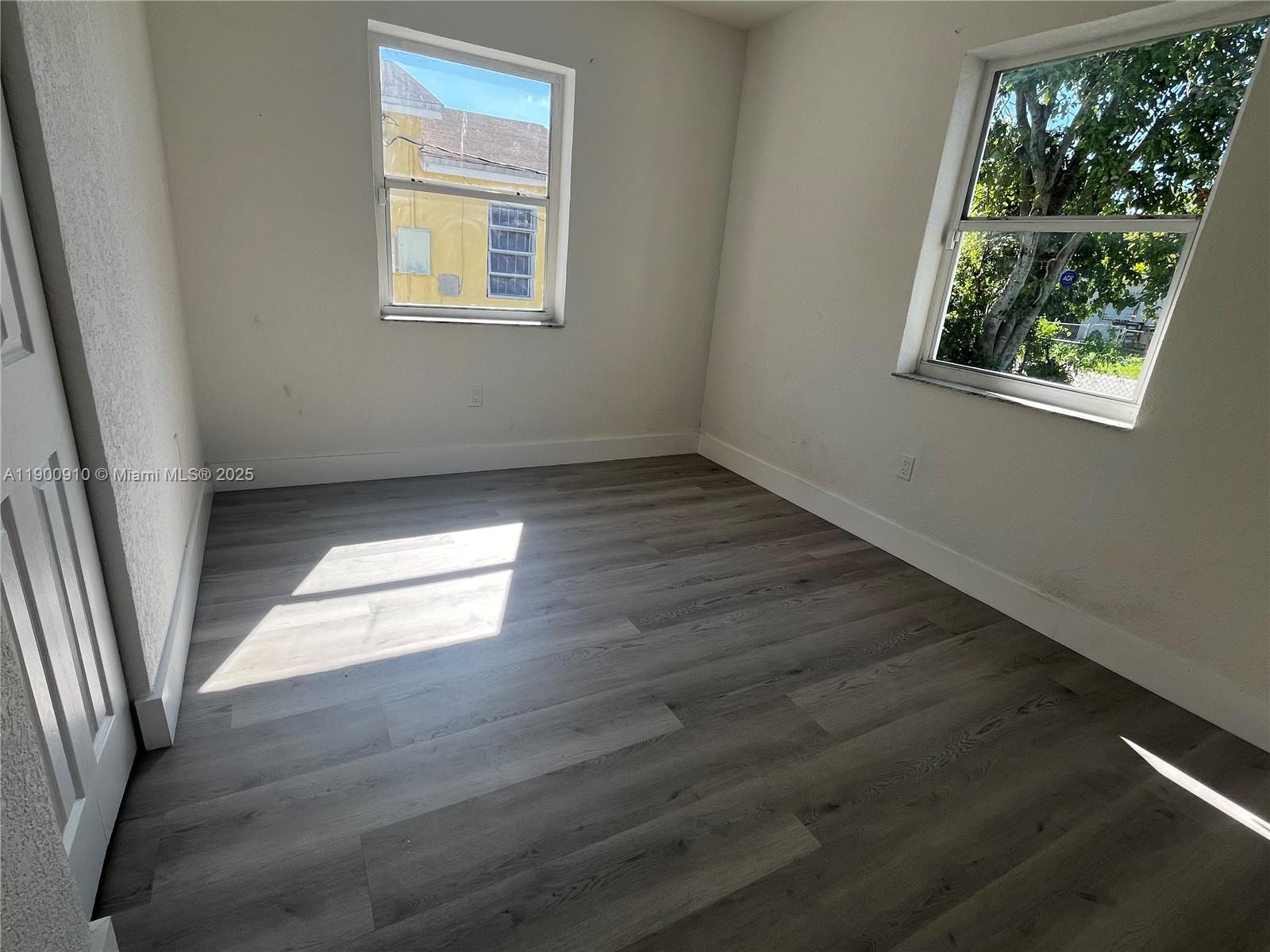 1923 Northwest 66th Street Miami, FL 33147 - Photo 16 of 27 an empty room with wooden floor and windows