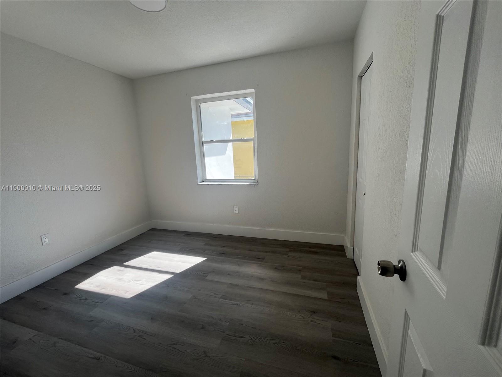 1923 Northwest 66th Street Miami, FL 33147 - Photo 21 of 27 an empty room with wooden floor and windows