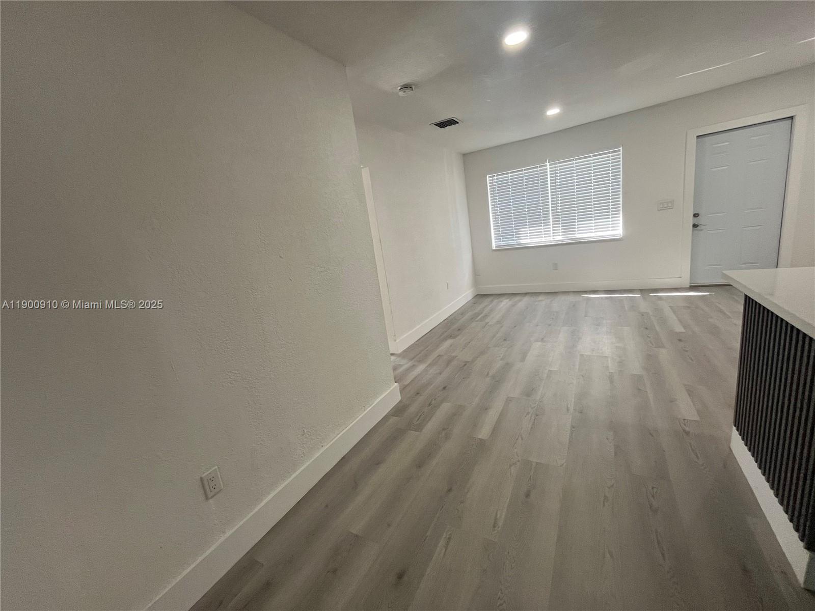 1923 Northwest 66th Street Miami, FL 33147 - Photo 5 of 27 wooden floor in an empty room with a window
