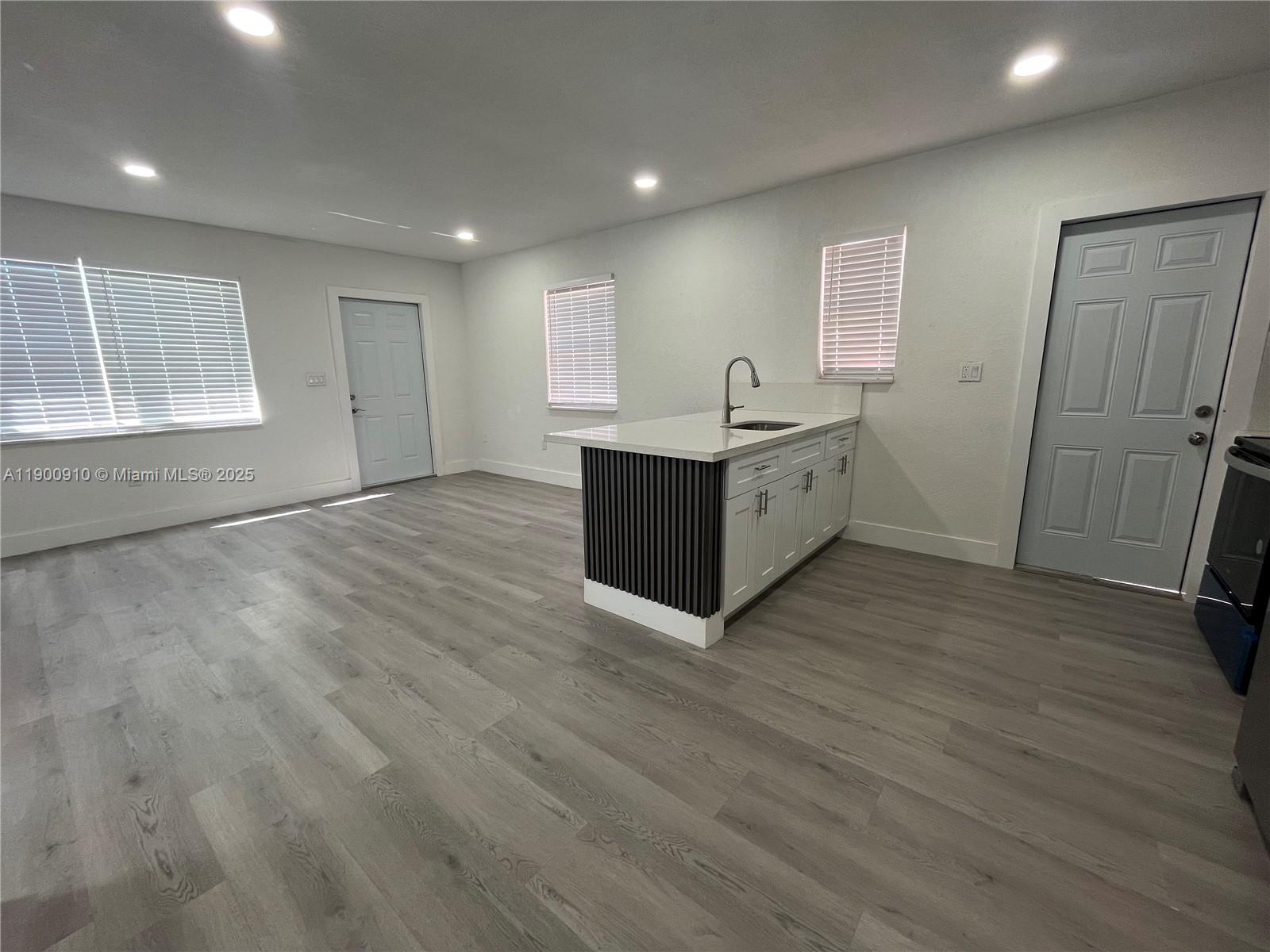 1923 Northwest 66th Street Miami, FL 33147 - Photo 8 of 27 a view of an empty room with wooden floor and a window
