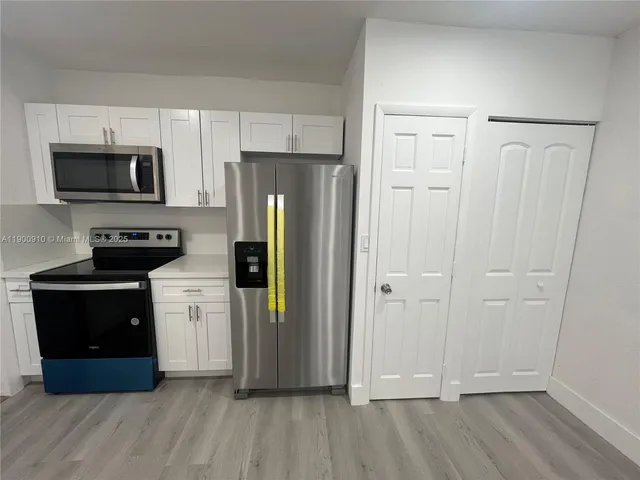 a kitchen with stainless steel appliances granite countertop a refrigerator and a stove top oven