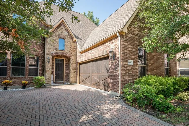 a view of a white house with a small yard and plants