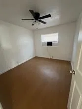 an empty room with a ceiling fan and a window