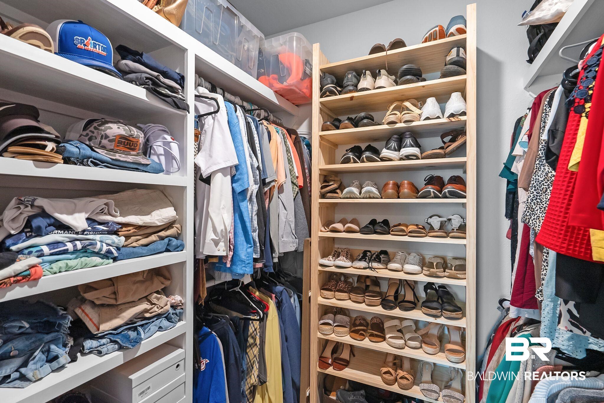 13966 Antler Hl Road Daphne, AL 36527 - Photo 20 of 44 Custom closet organization system featuring white shelving, hanging rods, and a freestanding natural wood shoe rack