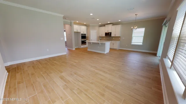 a view of kitchen with wooden floor and electronic appliances