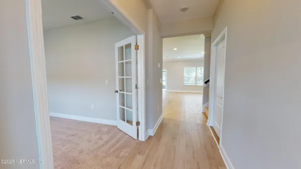 a view of a hallway with wooden floor
