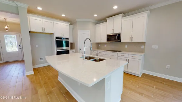 a kitchen with kitchen island a sink dishwasher a stove a refrigerator and microwave with wooden floor