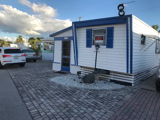 a view of a house with a barbeque grill and wooden floor