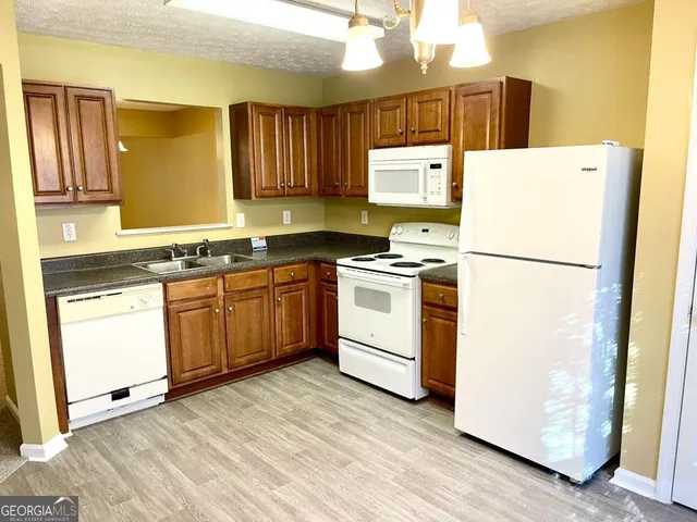 a kitchen with a sink a refrigerator and cabinets